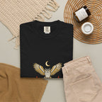 Black After Dark Owl Tee laid flat next to a woven basket and folded clothes