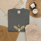 Pepper After Dark Owl Tee laid flat next to a woven basket and folded clothes